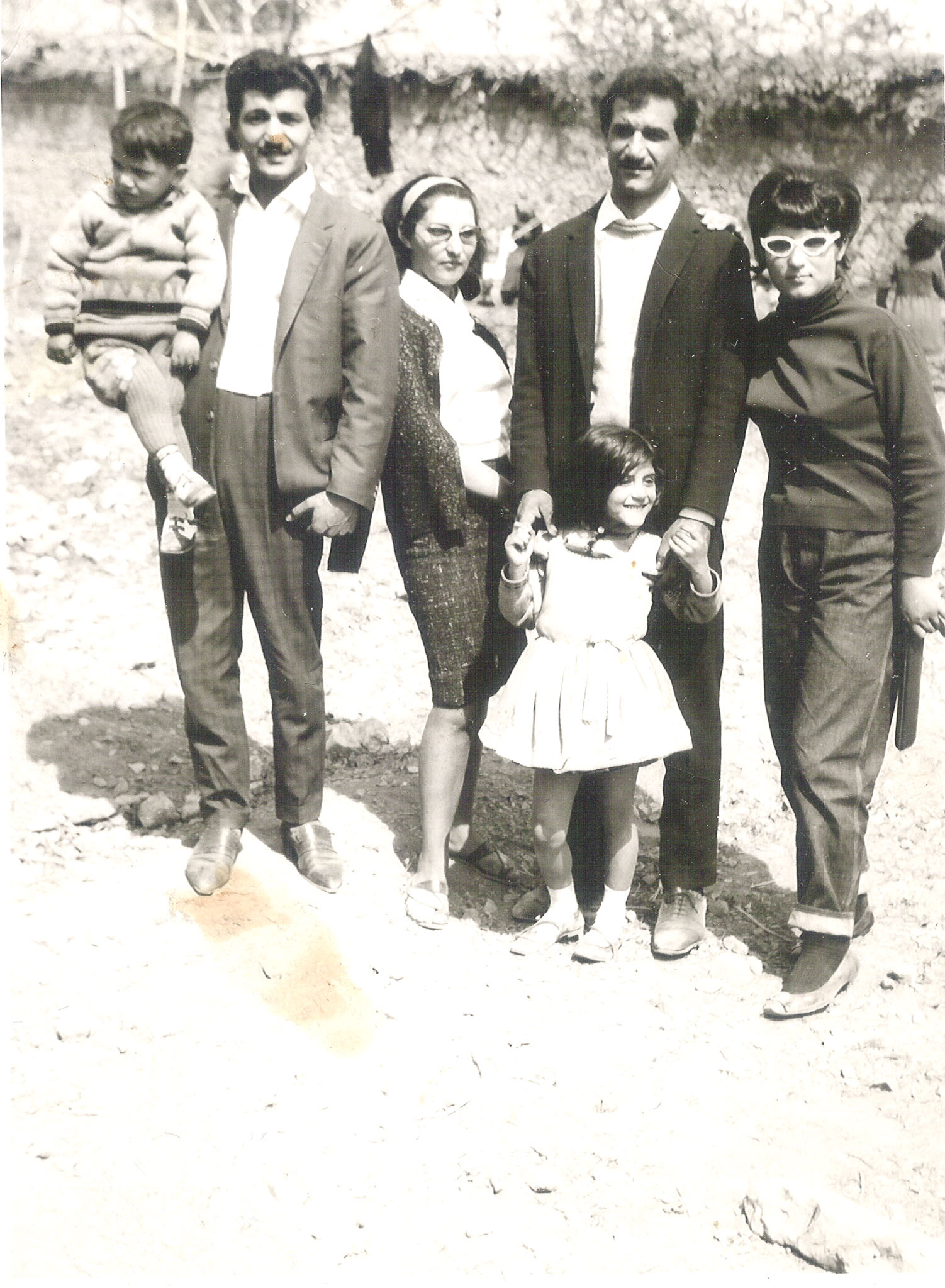 Iranian family in 1960s fashion featuring woman in cat-eye glasses.